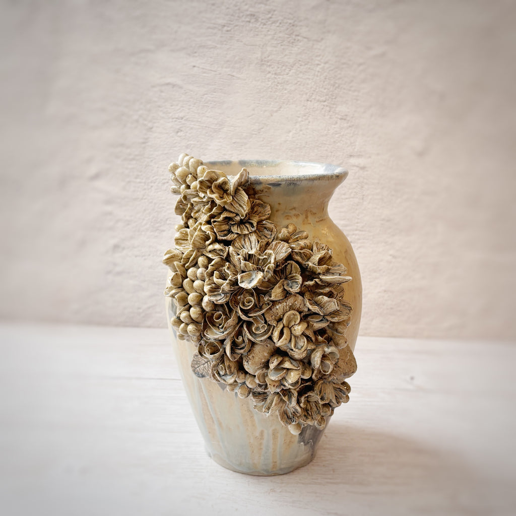 Jarrón con aplicacioenes de flores  en azules y arena