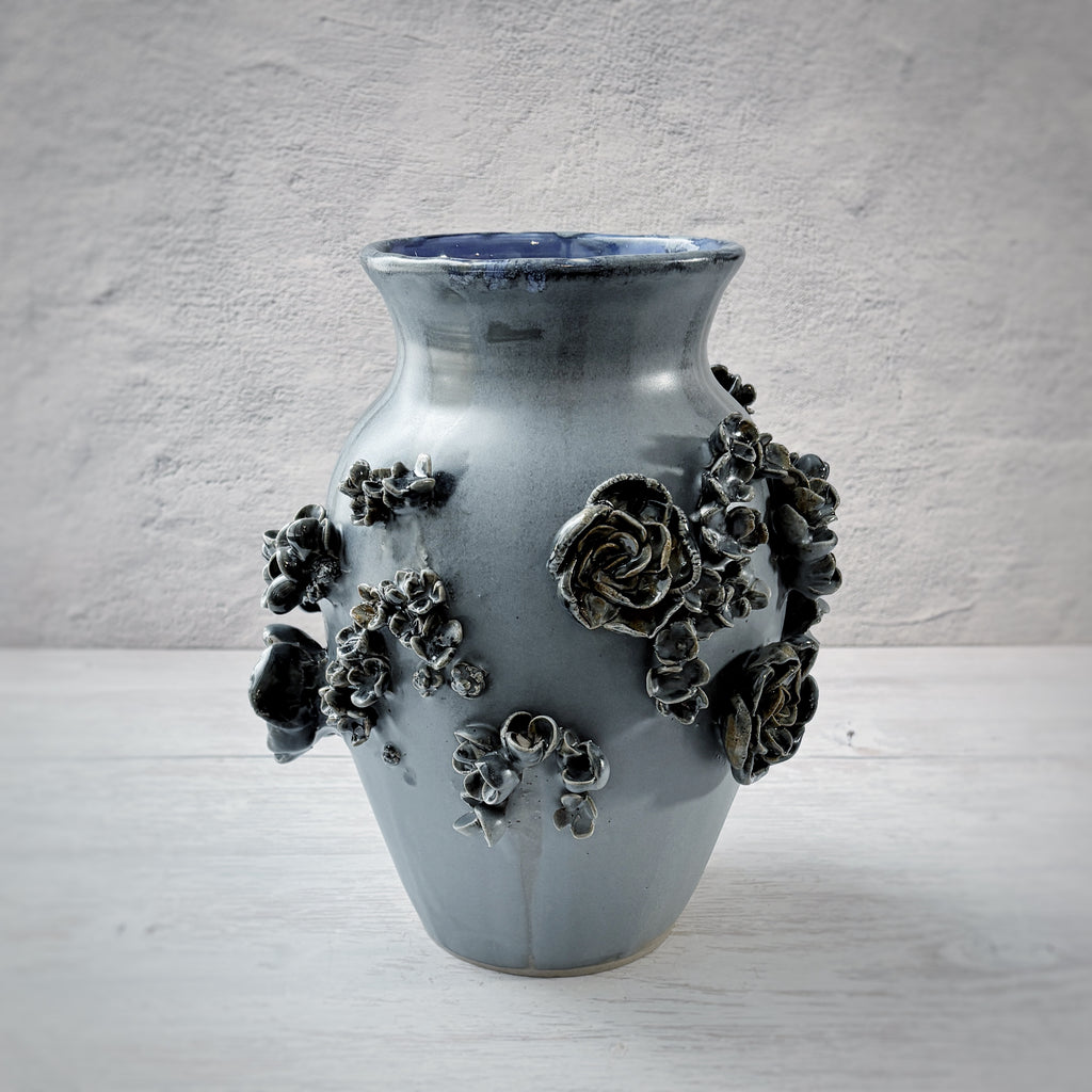 Jarrón con aplicacioenes de flores  en azul.