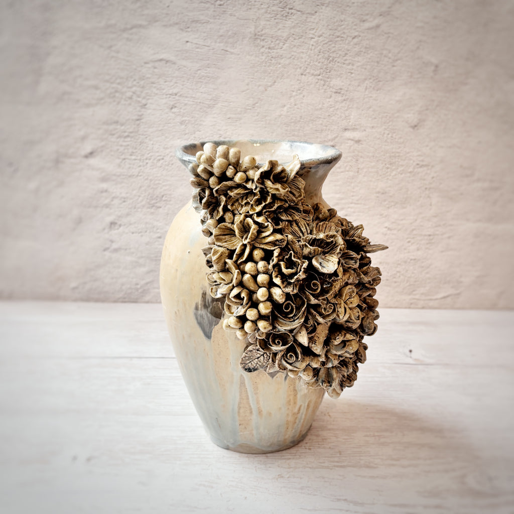 Jarrón con aplicacioenes de flores  en azules y arena