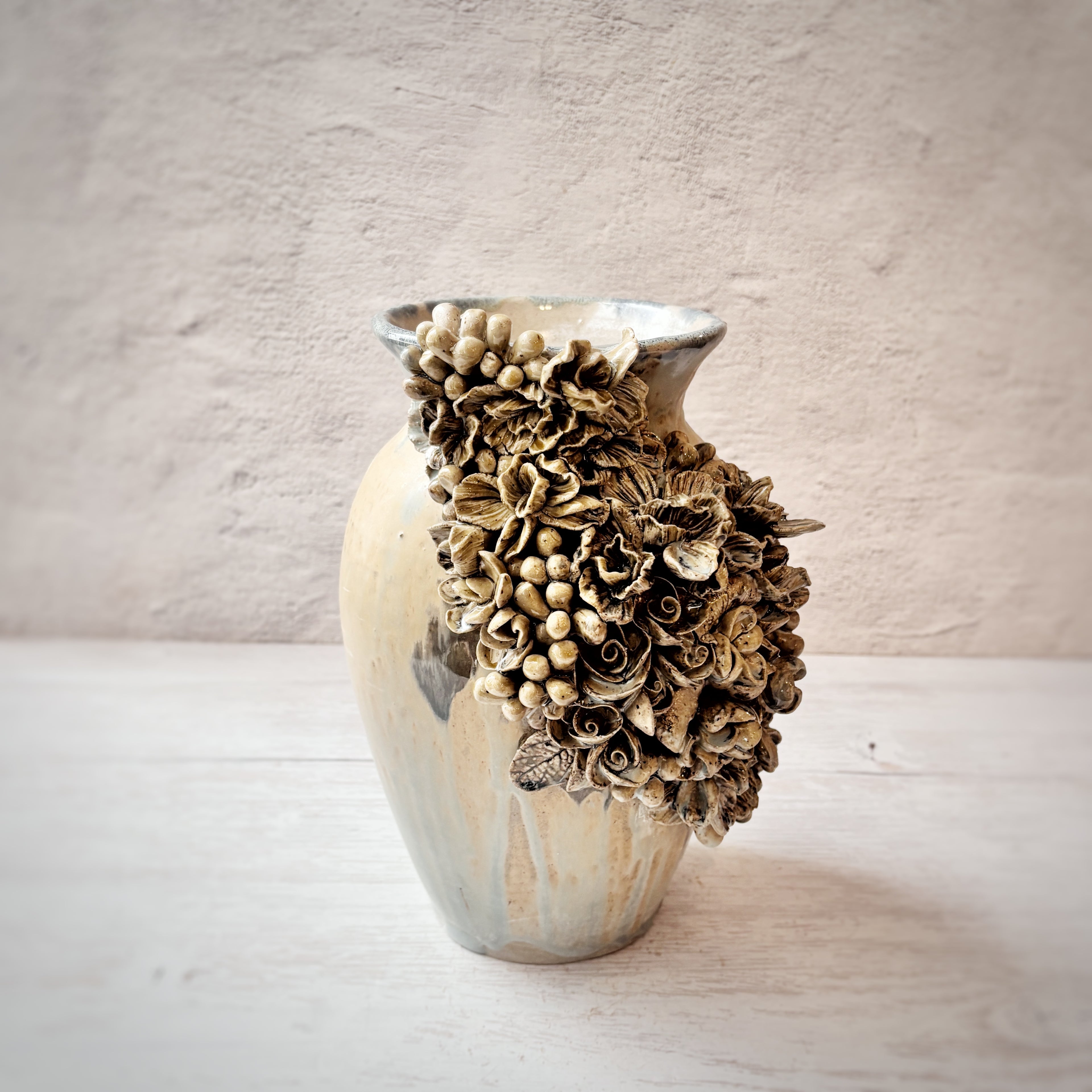 Jarrón con aplicacioenes de flores  en azules y arena