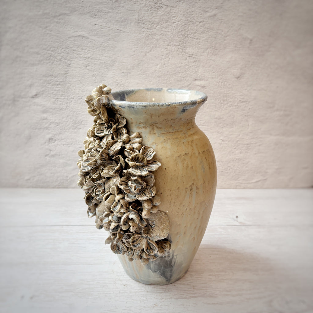 Jarrón con aplicacioenes de flores  en azules y arena