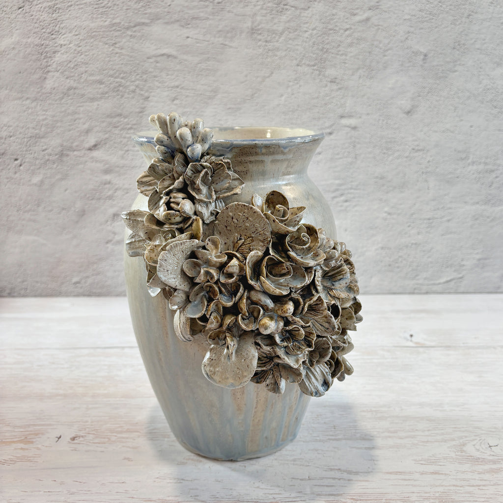 Jarrón con aplicacioenes de flores  en azules y arena