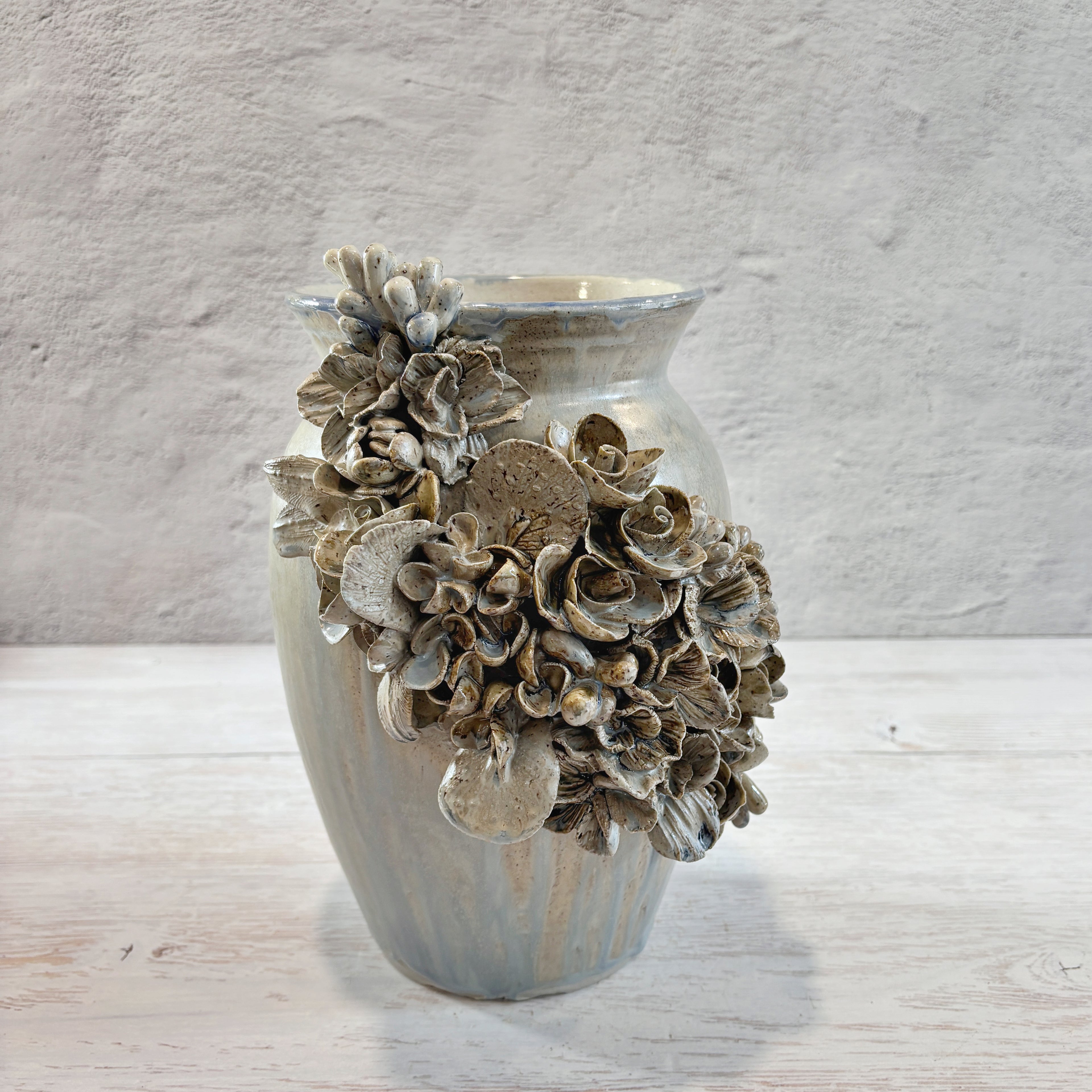 Jarrón con aplicacioenes de flores  en azules y arena